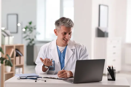 Doctor waving hello on a video consult
