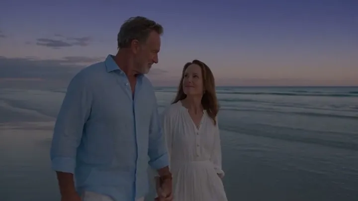 Couple walking on a beach at dusk